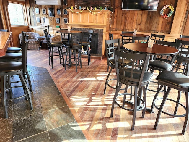 dining area featuring wooden walls and a wall mounted AC