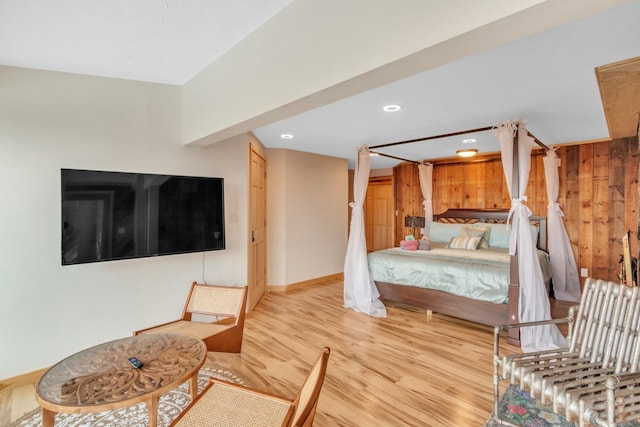 bedroom with wood finished floors, wood walls, and recessed lighting