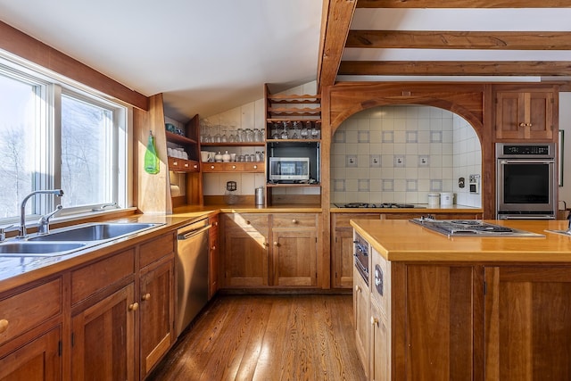kitchen with vaulted ceiling, light wood-style flooring, brown cabinets, stainless steel appliances, and a sink