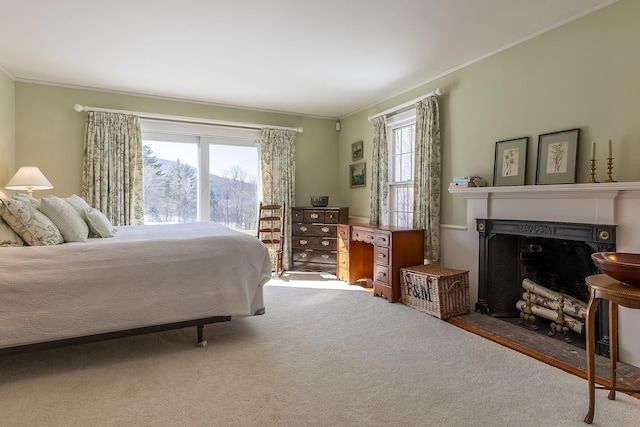 bedroom featuring ornamental molding, access to exterior, a fireplace with flush hearth, and carpet floors