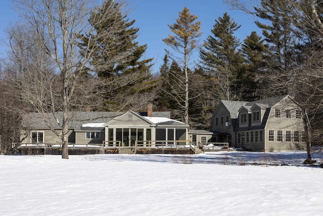 snow covered back of property with a gambrel roof
