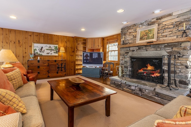 living room with wood walls, recessed lighting, carpet, and a fireplace