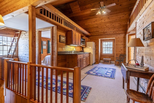 kitchen with ceiling fan, freestanding refrigerator, wooden ceiling, stainless steel microwave, and dark countertops