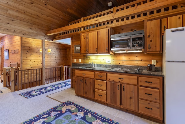 kitchen featuring black electric stovetop, wood walls, freestanding refrigerator, and wood ceiling