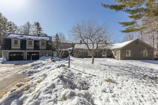 view of front facade featuring a garage and a gambrel roof
