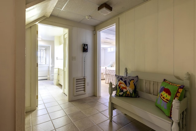 hallway with light tile patterned floors, a paneled ceiling, and a baseboard radiator