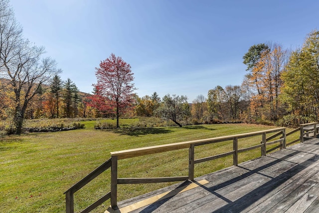 wooden deck featuring a view of trees and a lawn
