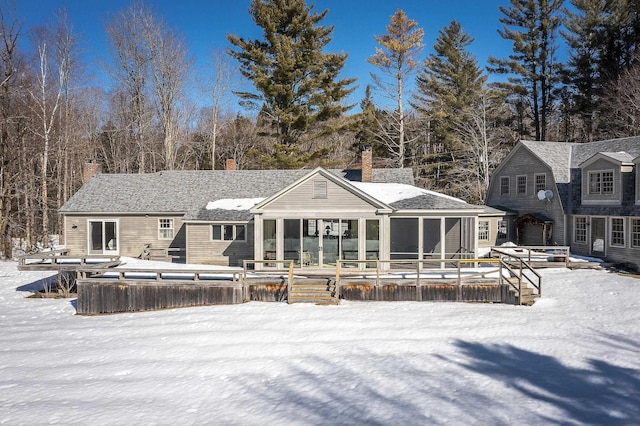 snow covered house with a wooden deck