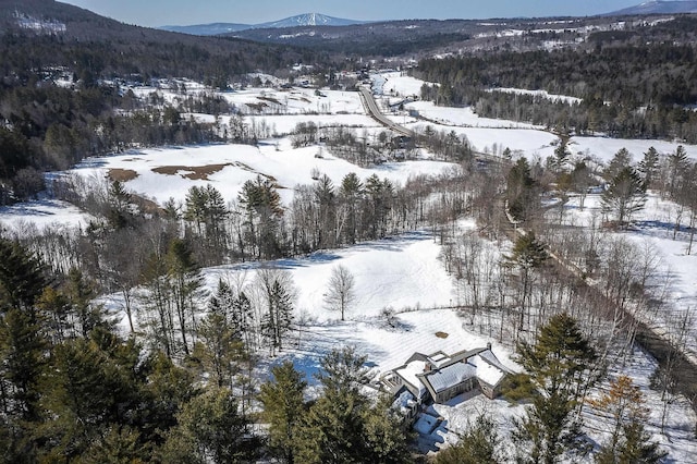 snowy aerial view featuring a mountain view and a forest view