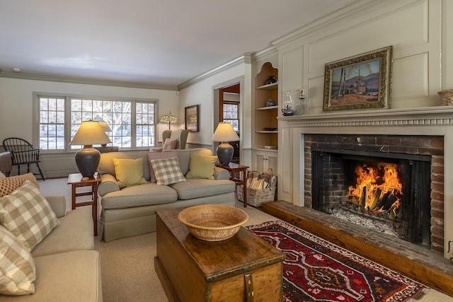 carpeted living area with a fireplace, built in features, and crown molding