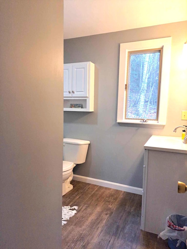 bathroom with vanity, baseboards, toilet, and wood finished floors