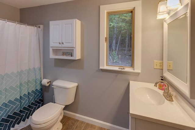 bathroom featuring vanity, toilet, curtained shower, wood finished floors, and baseboards