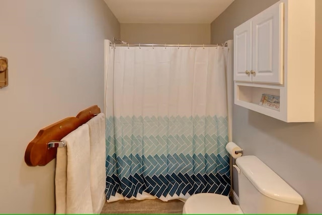 bathroom featuring a shower with curtain and toilet