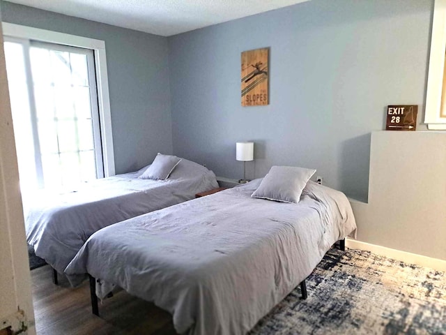 bedroom with baseboards and wood finished floors
