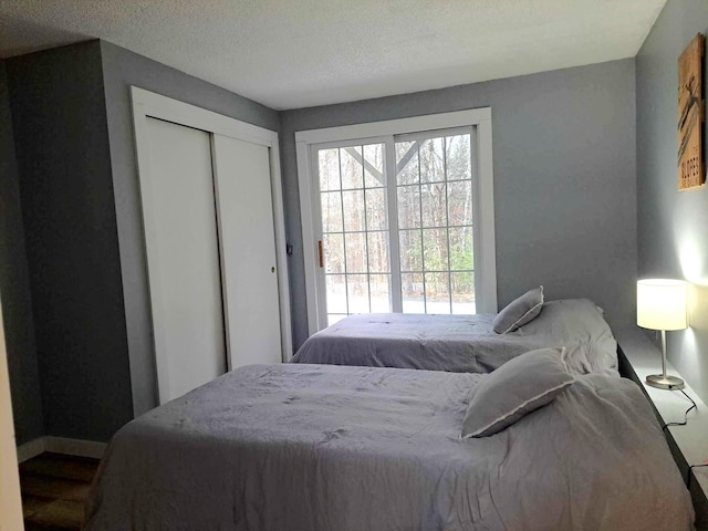 bedroom with baseboards, a closet, and a textured ceiling