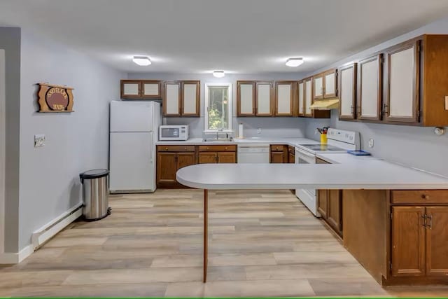 kitchen featuring a sink, light countertops, white appliances, under cabinet range hood, and baseboard heating