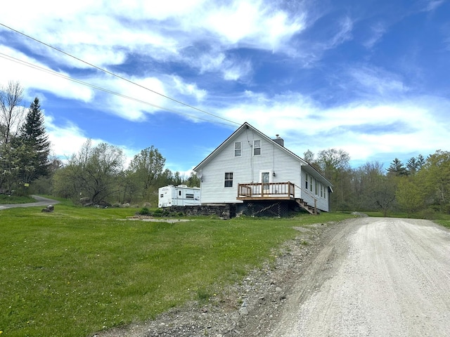 107 Ainsworth Rd, Woodbury, VT 05681 - view of home's exterior featuring a deck, a chimney, a lawn, and dirt driveway
