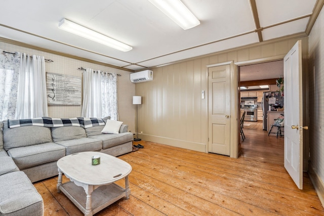 living area featuring a wall mounted AC and light wood-style floors