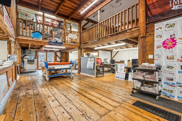 miscellaneous room featuring a towering ceiling and hardwood / wood-style flooring