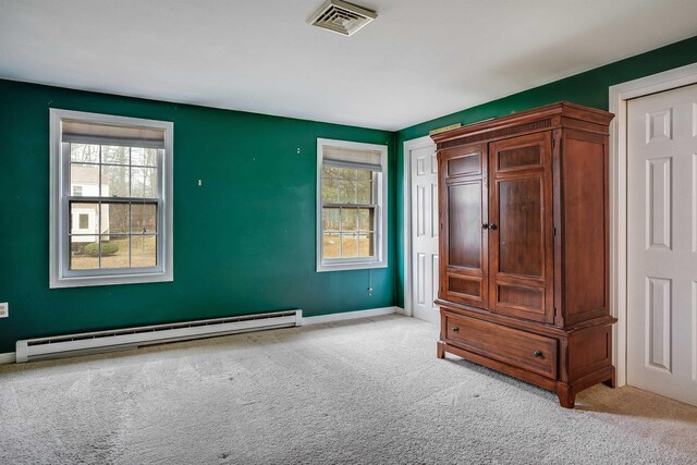 114 Winterwood Dr Unit 114, Londonderry, NH 03053 - unfurnished bedroom featuring visible vents, multiple windows, a baseboard heating unit, and carpet floors