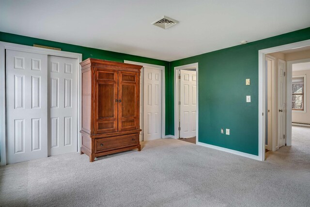 114 Winterwood Dr Unit 114, Londonderry, NH 03053 - unfurnished bedroom with light carpet, baseboards, two closets, and visible vents
