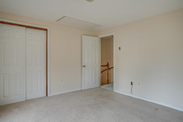 114 Winterwood Dr Unit 114, Londonderry, NH 03053 - unfurnished bedroom with baseboards, carpet flooring, a closet, and attic access