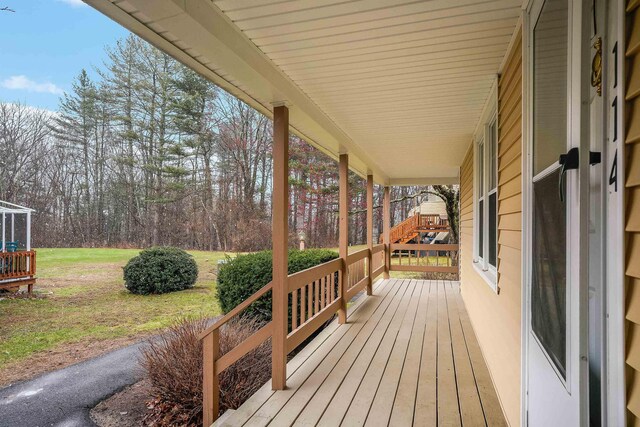 114 Winterwood Dr Unit 114, Londonderry, NH 03053 - deck featuring a porch and a lawn