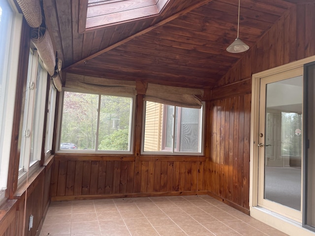 unfurnished sunroom featuring wood walls, lofted ceiling, and tile patterned flooring