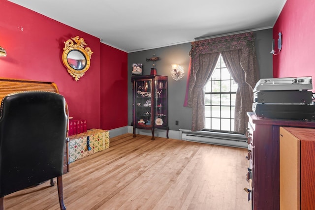 office space featuring crown molding, baseboards, a baseboard heating unit, and wood finished floors