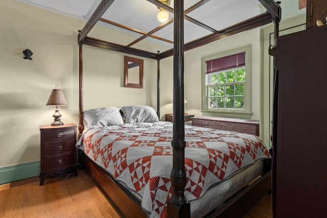 bedroom with crown molding and wood finished floors