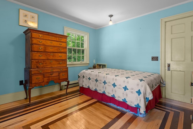 bedroom with baseboard heating, hardwood / wood-style flooring, and crown molding