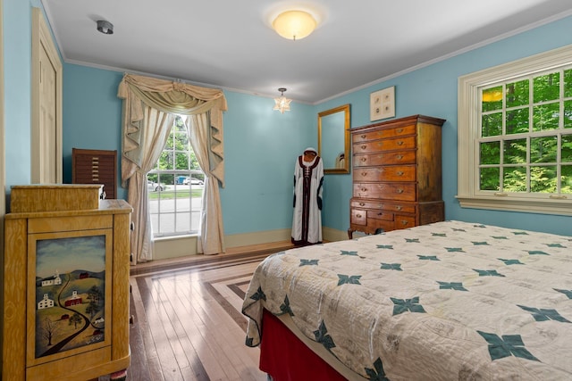 bedroom featuring crown molding, baseboards, and hardwood / wood-style flooring
