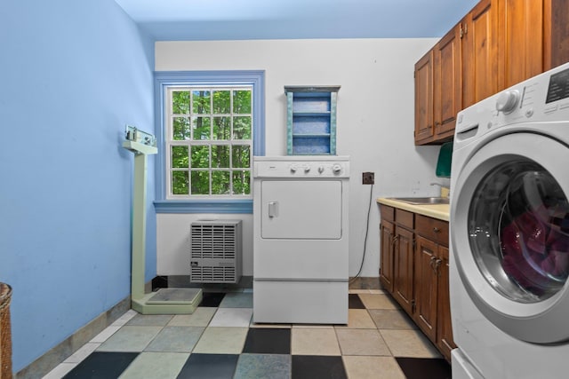 washroom with a sink, washer and dryer, baseboards, cabinet space, and heating unit