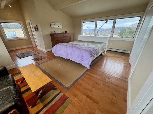 bedroom featuring a baseboard radiator, baseboards, vaulted ceiling with beams, and light wood-style floors
