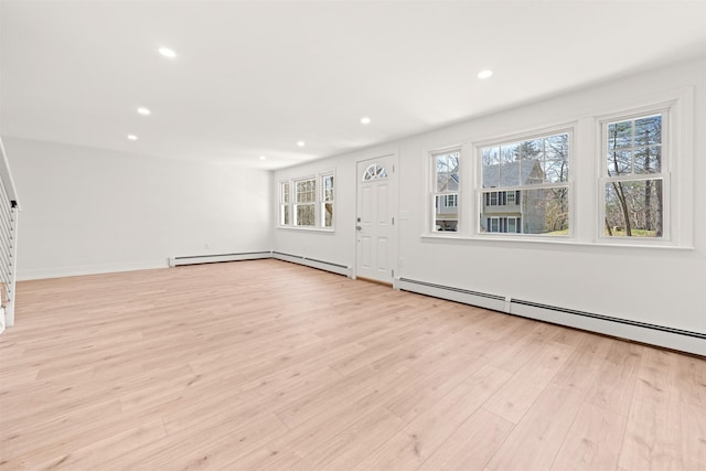unfurnished living room with baseboards, baseboard heating, recessed lighting, stairway, and light wood-style flooring