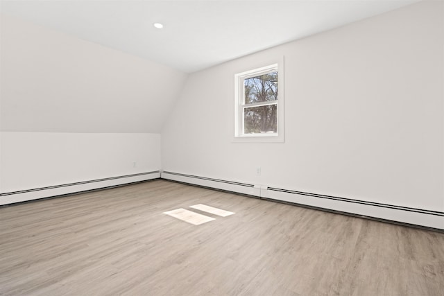 bonus room with a baseboard heating unit, wood finished floors, and lofted ceiling