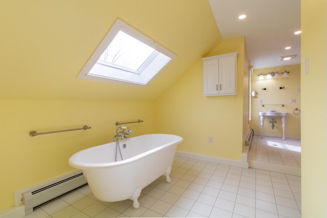 849 Mount Bess Rd, Charleston, VT 05872 - full bathroom with a freestanding tub, recessed lighting, vaulted ceiling with skylight, tile patterned flooring, and a baseboard radiator