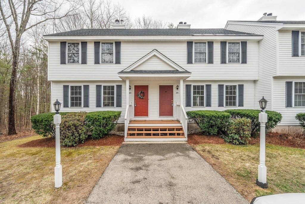 view of front of house featuring a front lawn and a chimney