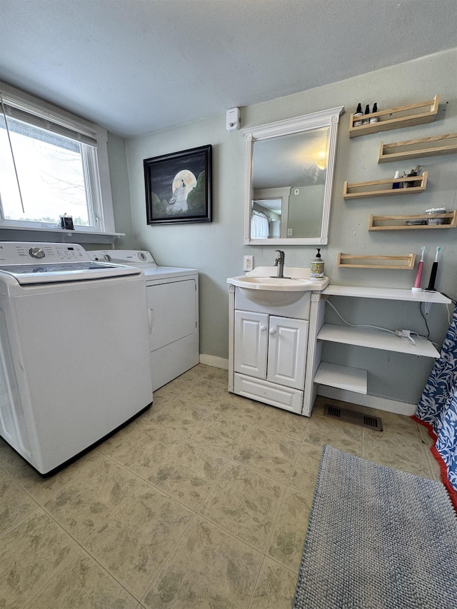 laundry area featuring a sink, baseboards, cabinet space, and washer and dryer