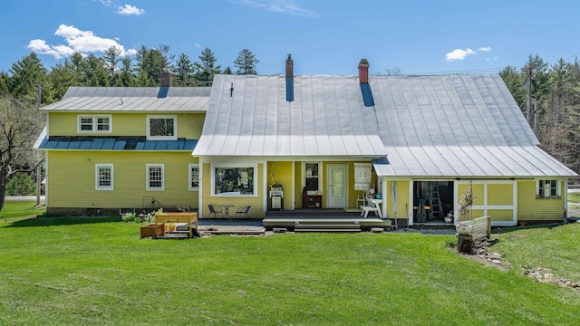 back of property with a chimney, a porch, a standing seam roof, a yard, and metal roof