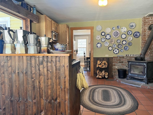 kitchen featuring tile patterned floors, a wood stove, and built in microwave