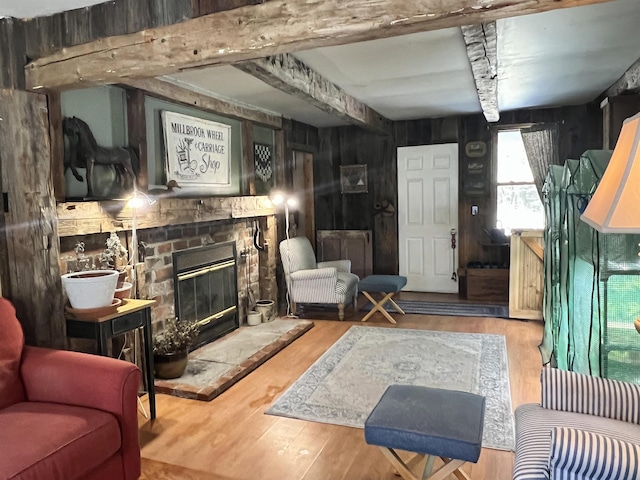 living area featuring a stone fireplace and wood finished floors