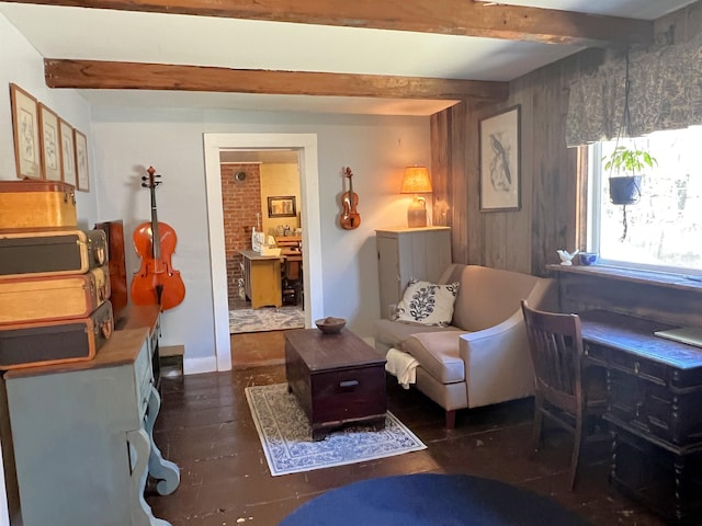 living area featuring beamed ceiling and wood walls