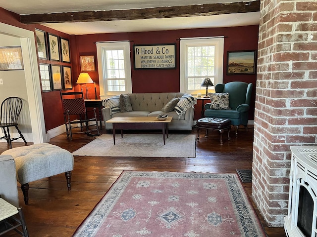 living area with wood-type flooring, baseboards, beamed ceiling, and a healthy amount of sunlight