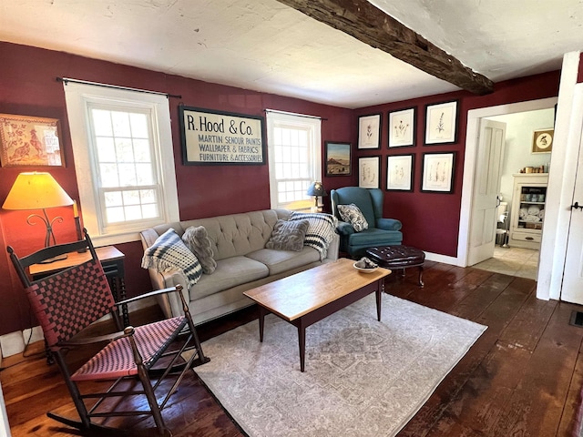 living area featuring baseboards, wood-type flooring, and beam ceiling