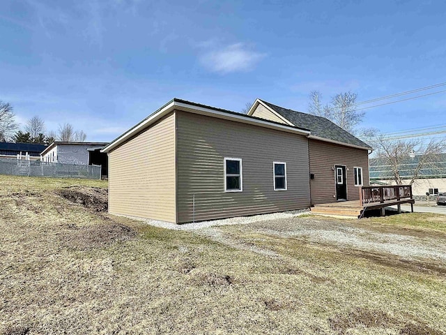 view of side of home featuring a deck and fence