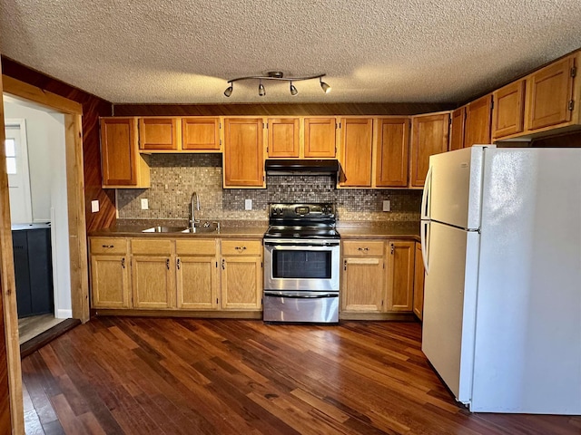 kitchen featuring tasteful backsplash, a sink, freestanding refrigerator, electric stove, and under cabinet range hood