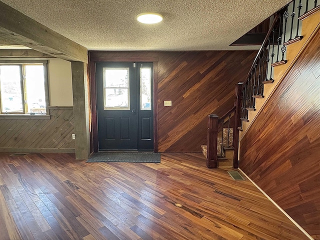 entrance foyer with stairway, plenty of natural light, and hardwood / wood-style floors