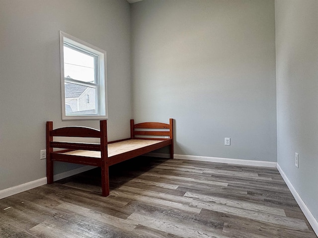 bedroom with wood finished floors and baseboards