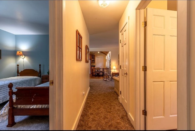 hall featuring carpet flooring and baseboards